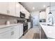 This kitchen features white cabinets, stainless appliances and an extended countertop for food preparation at 4033 Union Ln, North Port, FL 34288