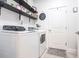Laundry room with white washer and dryer and decor shelves at 4033 Union Ln, North Port, FL 34288