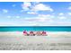 Beautiful white sandy beach with people enjoying the sun under a white umbrella at 408 Cerromar S Cir # 331, Venice, FL 34293