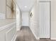 Inviting hallway featuring wood flooring, wainscoting, and decorative wall art at 408 Cerromar S Cir # 331, Venice, FL 34293