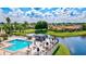 Breathtaking aerial view of the community pool, outdoor seating, and picturesque lake setting at 4114 Murfield E Dr, Bradenton, FL 34203