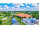 Aerial view showcasing a clubhouse, pool, tennis courts, walking bridge, and golf course in a vibrant community setting at 4114 Murfield E Dr, Bradenton, FL 34203