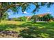 Spacious backyard with lush lawn, mature trees, and inviting screened-in patios for comfortable outdoor living at 4114 Murfield E Dr, Bradenton, FL 34203
