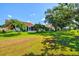 Expansive backyard with lush green grass and mature trees offering ample shade and privacy at 4114 Murfield E Dr, Bradenton, FL 34203