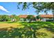 Picturesque backyard with manicured lawn, vibrant palm trees, and a well-maintained home exterior at 4114 Murfield E Dr, Bradenton, FL 34203