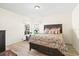 Inviting bedroom featuring wood-look floors, a cozy queen bed, and a sunlit window with serene outdoor views at 4114 Murfield E Dr, Bradenton, FL 34203