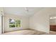 Bright bedroom with wood tile floors, ceiling fan, window with view and connected bathroom at 4114 Murfield E Dr, Bradenton, FL 34203