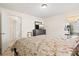 Well-lit bedroom boasts wood-look floors, comfortable queen bed, and access to an adjacent hallway at 4114 Murfield E Dr, Bradenton, FL 34203