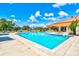 Large community pool with blue umbrellas and lounge chairs; perfect for relaxation and recreation at 4114 Murfield E Dr, Bradenton, FL 34203