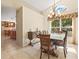 Bright dining area with a large window and chandelier, flowing into the kitchen at 4114 Murfield E Dr, Bradenton, FL 34203
