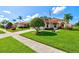 Inviting single-story home featuring a lush lawn and mature palm trees, showcasing curb appeal at 4114 Murfield E Dr, Bradenton, FL 34203