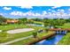 Scenic view of the golf course with a wooden bridge, sand trap, lush greenery, and players enjoying the day at 4114 Murfield E Dr, Bradenton, FL 34203