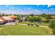 Scenic golf course view featuring a clubhouse, walking bridge over water, lush greenery, and golf carts under a blue sky with clouds at 4114 Murfield E Dr, Bradenton, FL 34203