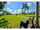 Serene green space featuring a bench, walking path, and expansive lawn under a clear blue sky at 4114 Murfield E Dr, Bradenton, FL 34203