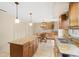 Open kitchen featuring an island with granite countertops, stainless steel sink, and breakfast area with wooden table at 4114 Murfield E Dr, Bradenton, FL 34203
