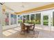 Enclosed lanai with tile flooring, ceiling fan, and views of the landscaped backyard at 4114 Murfield E Dr, Bradenton, FL 34203