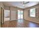 Bedroom features wood-look floors, ceiling fan, and sliding glass doors to screened pool at 4150 Otoole St, North Port, FL 34291