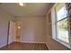 Bedroom features wood-look floors, neutral paint, shuttered window, and view of front door at 4150 Otoole St, North Port, FL 34291