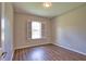 Bedroom features wood-look floors, neutral paint, shuttered window, and modern lighting at 4150 Otoole St, North Port, FL 34291