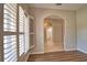 Inviting entryway features wood floors, arched doorways, and bright natural light from window with white shutters at 4150 Otoole St, North Port, FL 34291