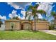 Charming single-story home with a well-manicured lawn, mature palm trees and an attached two-car garage at 4150 Otoole St, North Port, FL 34291