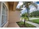 Exterior shot with well-placed trees, showcasing the side of a tan house with a sidewalk and green grass at 4150 Otoole St, North Port, FL 34291