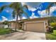 Inviting exterior featuring a two-car garage, well-maintained lawn, and mature landscaping under a sunny sky at 4150 Otoole St, North Port, FL 34291