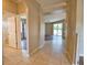 Open-concept living space with tile flooring transitioning to wood, leading to a bright, airy living room at 4150 Otoole St, North Port, FL 34291
