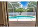 Inviting screened-in pool with clear blue water, surrounded by lush tropical landscaping, creating a private backyard oasis at 4150 Otoole St, North Port, FL 34291