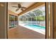 Screened lanai features sparkling pool, mature trees, and ceiling fan for comfort at 4150 Otoole St, North Port, FL 34291