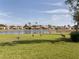 A manicured backyard and a serene pond featuring a fountain and cranes at 4831 Summertree Rd, Venice, FL 34293