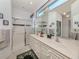 Bright bathroom features a double sink vanity, a large mirror, and a step-in shower with sliding glass doors at 4831 Summertree Rd, Venice, FL 34293
