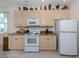 Kitchen features neutral cabinets, granite countertops, and modern white appliances at 4831 Summertree Rd, Venice, FL 34293