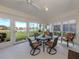 This screened lanai features great natural light, views of the pond, and a comfortable dining set at 4831 Summertree Rd, Venice, FL 34293