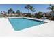 Community swimming pool with lounge chairs and tables surrounded by lush landscaping and views of the neighborhood at 4831 Summertree Rd, Venice, FL 34293