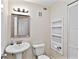 This half bathroom includes a white vanity, toilet, and storage shelves at 500 Park S Blvd # 33, Venice, FL 34285