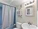 A full bathroom includes a shower with blue tile, white vanity, and nautical decor at 500 Park S Blvd # 33, Venice, FL 34285