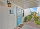 Charming home entrance with a teal door, welcome sign, and lush tropical plants at 500 Park S Blvd # 33, Venice, FL 34285