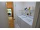 Convenient laundry room equipped with washer, dryer, shelving, and tile flooring, steps from the outside patio at 505 Duke Rd, Venice, FL 34293