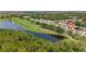 An aerial view of the property with a pond, the surrounding neighborhood and lush greenery at 511 Wexford Dr, Venice, FL 34293