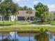Water view single Gathering home featuring a screened lanai bordered by mature trees and well kept lawn at 511 Wexford Dr, Venice, FL 34293