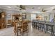 Open-concept dining room with wood-look flooring, open breakfast bar, and a ceiling fan at 511 Wexford Dr, Venice, FL 34293
