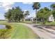 Scenic exterior view of the home, featuring a long driveway, landscaping and a lush green lawn at 511 Wexford Dr, Venice, FL 34293