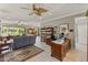 Spacious living area with tile flooring, a ceiling fan, backyard views, and ample natural light at 511 Wexford Dr, Venice, FL 34293