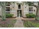 Attractive three-story condo building with stairs and balconies surrounded by mature trees and landscaping at 5134 Northridge Rd # 303, Sarasota, FL 34238