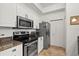 Well-lit kitchen featuring stainless steel appliances, granite countertops, and white cabinetry at 5134 Northridge Rd # 303, Sarasota, FL 34238
