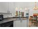 Open kitchen with granite counters, white cabinetry, and views into living and dining area at 5134 Northridge Rd # 303, Sarasota, FL 34238