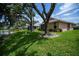 Backyard with mature trees and landscaping next to a lake at 519 Catalina Isles Cir, Venice, FL 34292