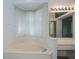 Bright bathroom features a soaking tub with a large window and sheer curtains at 519 Catalina Isles Cir, Venice, FL 34292