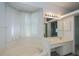 Bright bathroom features a soaking tub, vanity and a large window with sheer curtains at 519 Catalina Isles Cir, Venice, FL 34292